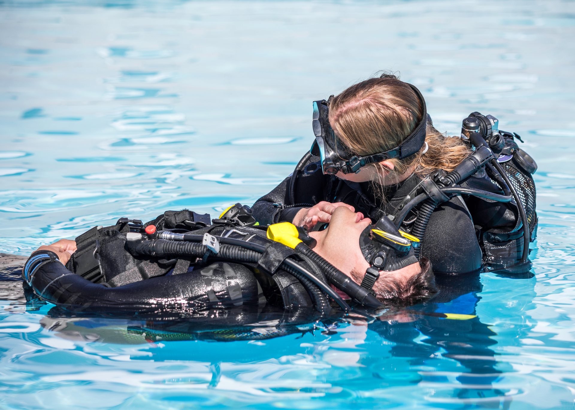 Scuba diver practising rescue skills with another diver at the surface